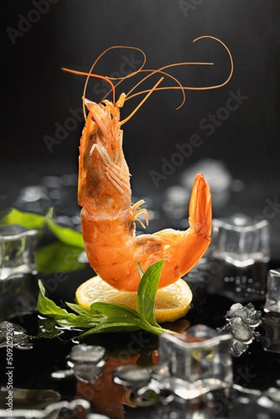 Obraz Flying prawns on lemon on dark background with ice. Creative design of seafood cooking concept.