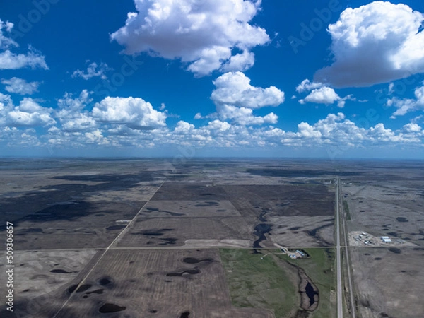 Obraz Aerial view of long, straight prairie highways stretching under a cloudy blue sky