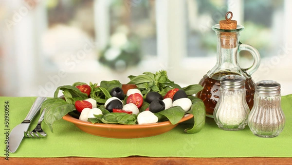 Fototapeta cheese mozzarella with vegetables in the plate with fork and