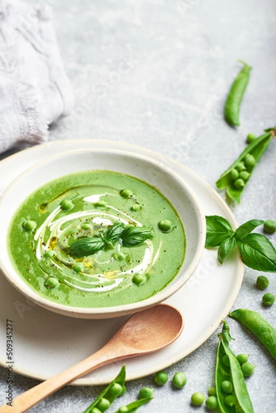 Fototapeta Green peas soup. Healthy vegan green peas soup served in bowl on rustic table.
