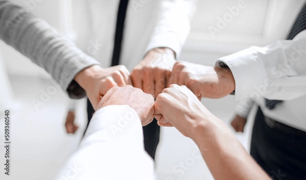 Obraz Close up .businessman and businesswoman making a fist bump on building background