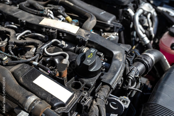 Fototapeta Engine compartment in a diesel car, visible closed oil filler in black and engine parts.