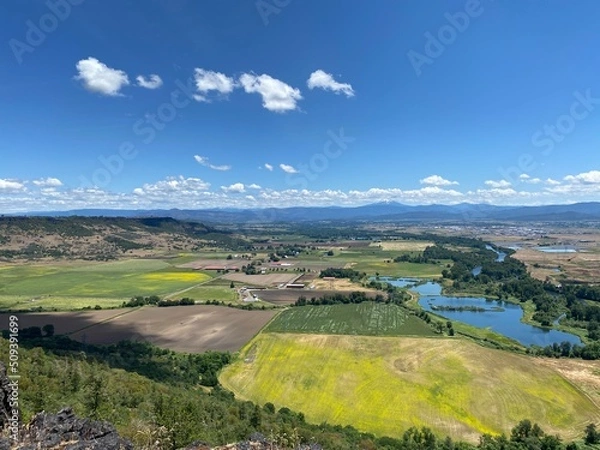 Fototapeta Aerial View of the lush green Rogue Valley in Southern Oregon from atop Table Rock Plateau with fields of green and yellow wildflowers.