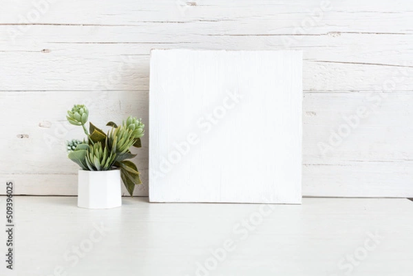 Fototapeta White square sign on the table with a flower.
