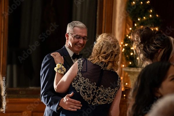 Fototapeta Cute older couple dancing at a party reception with lights