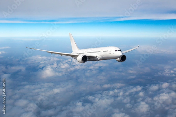 Fototapeta Passenger plane in flight. Aircraft fly high in the sky above the clouds. Front view of aircraft.