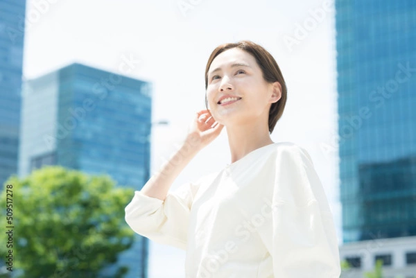 Fototapeta オフィス街に立つ笑顔の女性