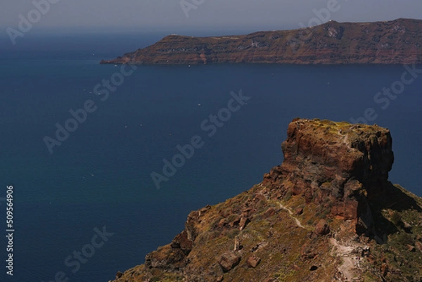 Fototapeta Landscape image of Skaros rock in Santorini. Daytime photo of famous landmark on Greek island. Photo shows the island of Thirasia in the background