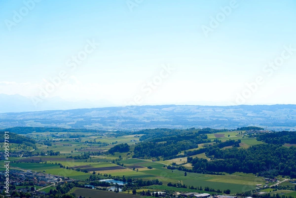 Fototapeta Aerial view of midland with agricultural fields, wood and hills seen from local mountain Uetliberg on a sunny spring day. Photo taken May 18th, 2022, Zurich, Switzerland.