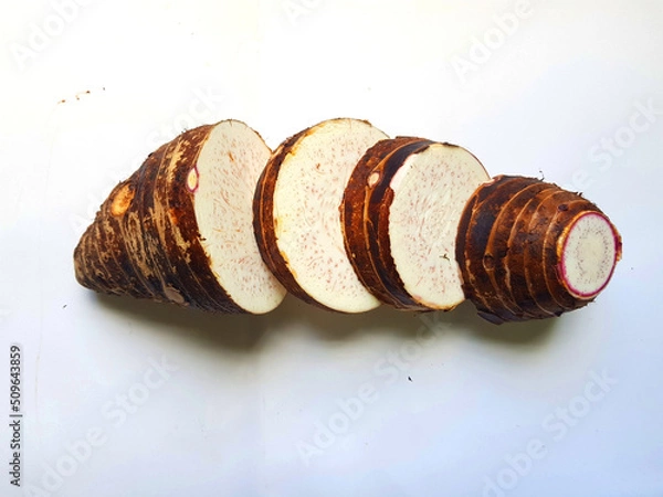 Fototapeta Taro slices and cube was cuted for cooking new dishes  on white and wood background.