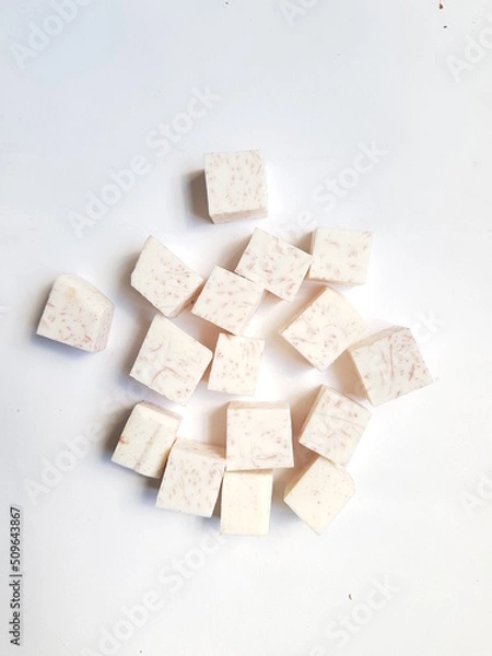 Fototapeta Taro slices and cube was cuted for cooking new dishes  on white and wood background.