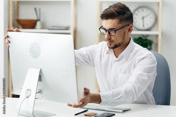Fototapeta businessmen in a white shirt sits at a computer work documentation technologies
