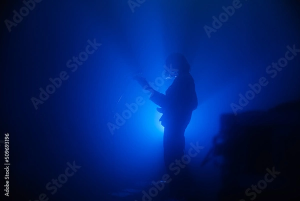 Obraz Guitarist silhouette on a stage in blue backlights 