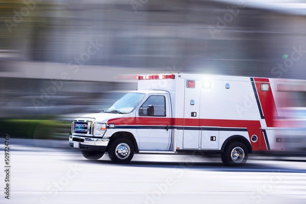 Fototapeta Blurred motion action view of an ambulance responding to the scene of an emergency.
