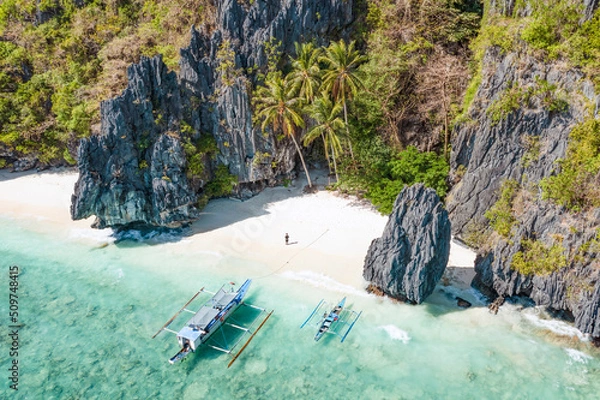 Obraz View from above, stunning aerial view of a person on the Entalula Beach, a white sand beach bathed by a crystal clear water. Entalula island, Bacuit Bay, El Nido, Palawan, Philippines.