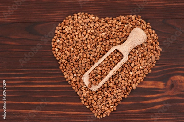 Fototapeta Buckwheat  grain on wooden background.
Raw and fresh buckwheat grain on wooden background from above, with copy space for text.
