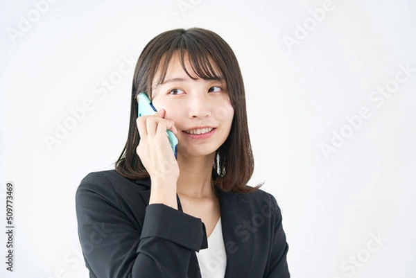 Fototapeta 白背景でスマホで電話をする女性