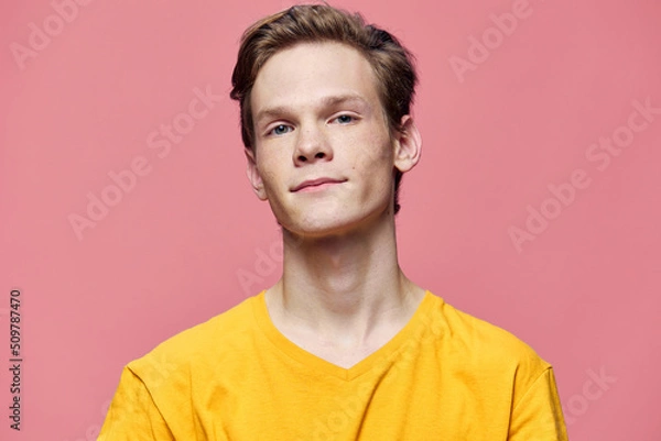 Fototapeta portrait of a handsome guy with freckles on a pink background