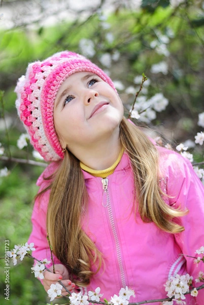 Fototapeta beautiful little girl near a flowering tree