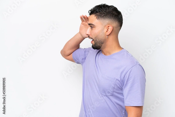 Fototapeta Young Arab handsome man isolated on white background with surprise expression while looking side