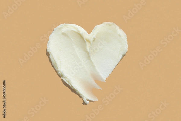 Fototapeta Heart shape shea butter cream texture smudge stroke on beige brown color background