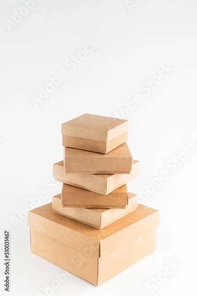 Fototapeta On a white background, many cardboard boxes are placed according to size.