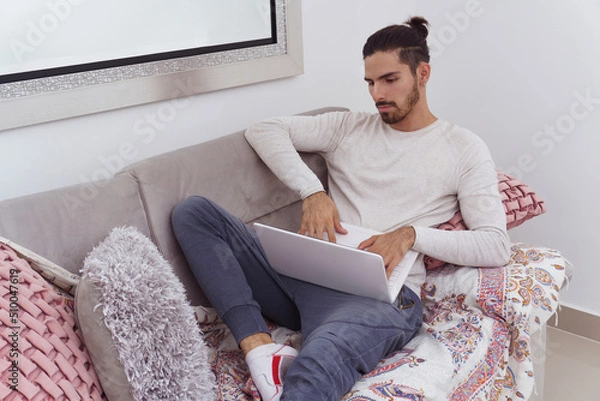 Obraz man lying on couch with his laptop