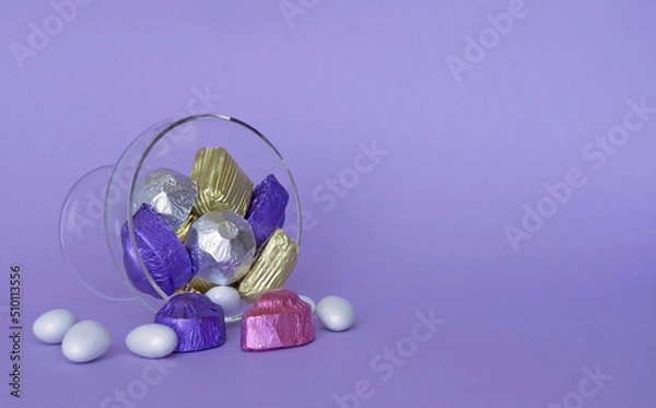 Fototapeta Feast Concept, Traditional Turkish Ramadan sweet sugar candy, and chocolates in glass bowl with purple background.