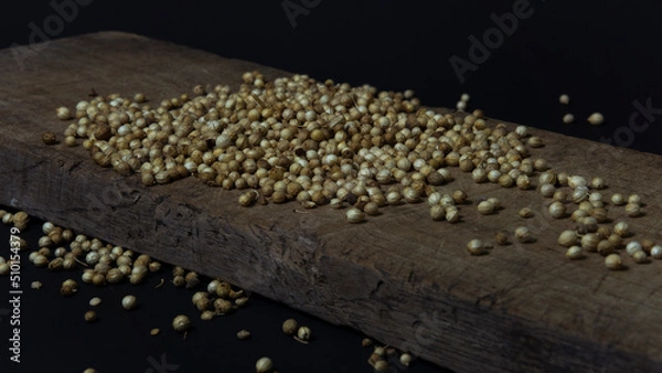 Fototapeta Photo of peppercorns on a wooden board on a black background. Suitable for design elements of spices and organic products.
