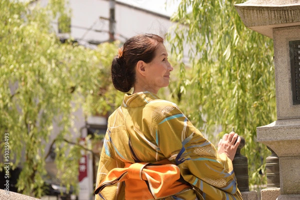 Obraz 浴衣を着て温泉街で振り向く笑顔のシニア女性