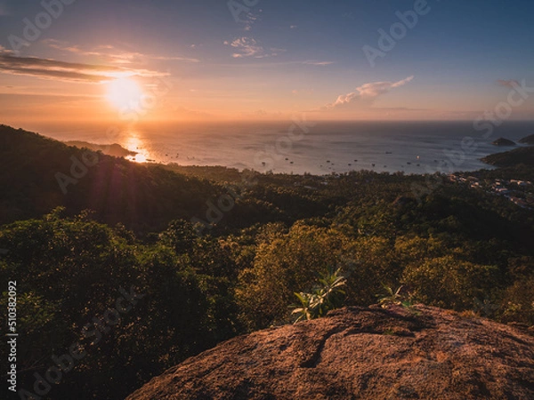 Fototapeta Scenic high angle view of sunset orange sky with sunbeam and Sairee beach in the peaceful evening. Shot from West Coast Viewpoint. Koh Tao Island, Surat Thani, Thailand.