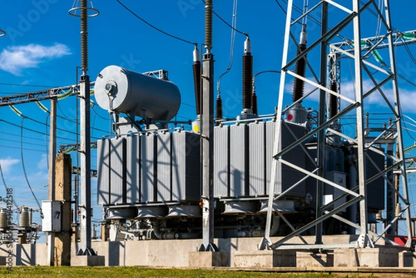 Fototapeta High voltage power transformer substation against the blue sky.
