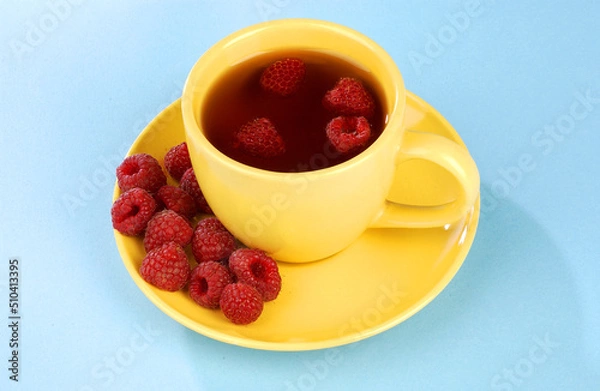 Fototapeta raspberry tea in a yellow cup