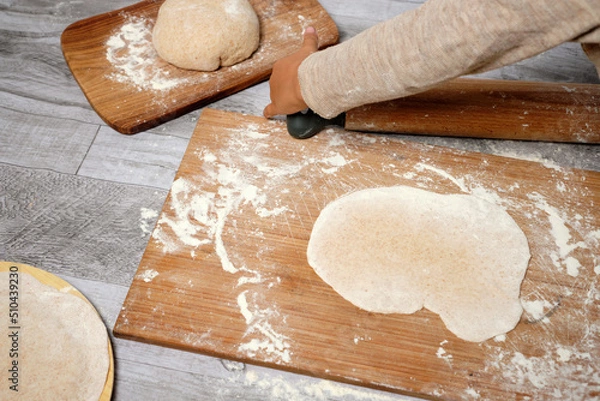 Fototapeta ready-to-cook dough, freshly kneaded by a small child. kitchen utensils on the table.