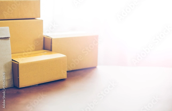 Fototapeta Lot of brown cardboard boxes copy space on table warehouse delivery service shipment goods. cardboard parcel box of product for deliver to customer. Online selling, e-commerce, packing concept.