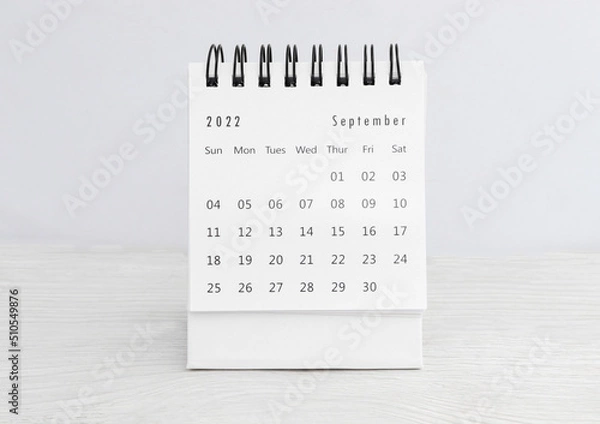 Fototapeta September 2022 desk calendar for planners and reminders on a wooden table on a white background
