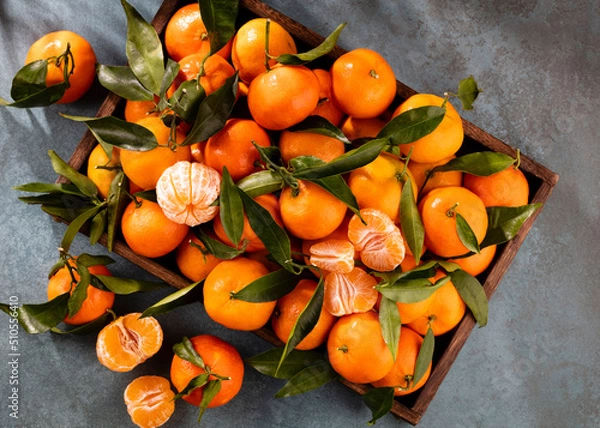 Fototapeta Fresh mandarin oranges fruit or tangerines with leaves in wooden box, top view