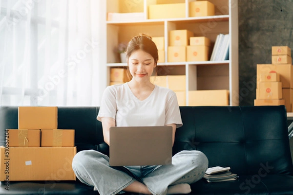 Obraz Asian woman working in modern warehouse and delivery service via modern technology