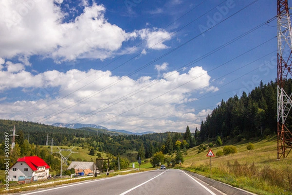 Fototapeta white clouds over mountain road view
