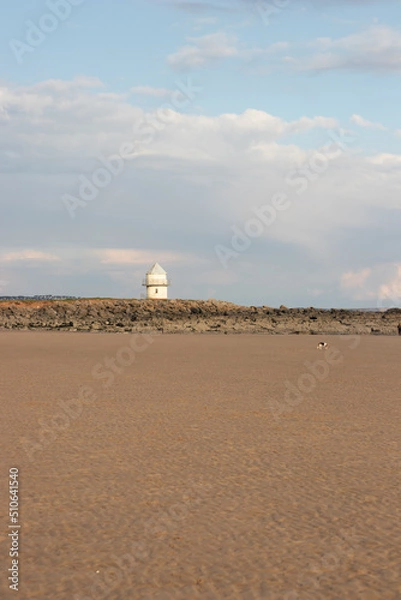 Fototapeta Lone lighthouse with an empty beach in the foreground