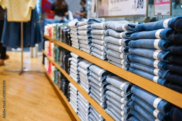 Fototapeta It was a brown shelf where clothes and blue jean pants of various grey tones were lined up in a clothing store where is the floor brown.