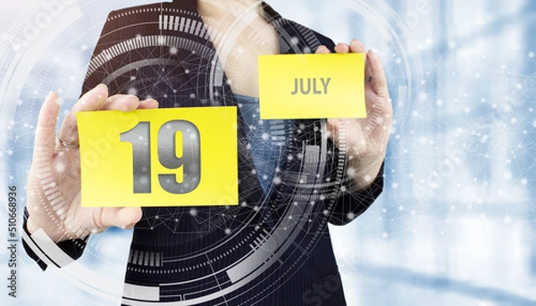 Fototapeta July 19th. Day 19 of month, Calendar date. Business woman hand hold yellow sheet with calendar date on blurred office background. Summer month, day of the year concept.