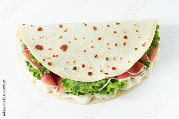 Obraz Italian street food flat lay with piadina isolated on a white background.  Piadina romagnola - Italian flatbread with prosciutto, salad and cream cheese