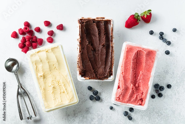 Obraz real Italian artisanal ice cream in packing box: chocolate, strawberries, vanilla with berries and a spoon