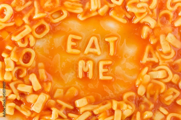 Fototapeta Pasta shaped letters spelling EAT ME in tomato sauce