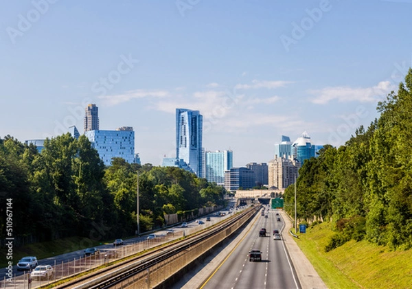 Fototapeta North Atlanta neighborhood of Buckhead displaying several buildings, city streets, hotels and high rises under a blue sky.