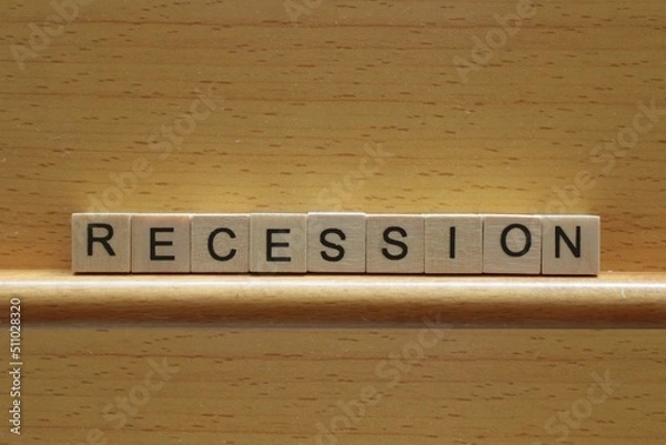 Fototapeta Recession concept, the word recession in wooden blocks on a wooden background with copy space