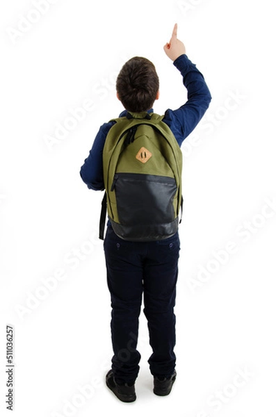 Obraz Back to school concept. Beautiful schoolboy with backpacks pointing at wall. Back view. Isolated on white background. Full length. Modern fashion teenage boy pointing on copy space