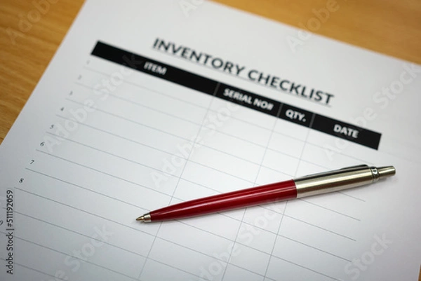 Fototapeta A luxury ballpoint pen is placed on blank form of inventory checklist table, using for checking goods in the factory storage. Business and object working concept. Selective focus.