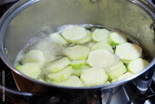 Fototapeta Slices of zucchini in the pot. Boiled vegetables, zucchini in a pan in hot water for blanching. Frozen Food Concept. It is called "Haslanmis Kabak" in Turkish. Diet or healthy food theme.